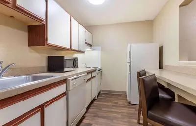a small kitchen with a sink and a refrigerator at Extended Stay America Suites - Fort Wayne - North in Fort Wayne
