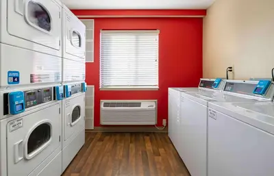 a red kitchen with a washer and dryer at Extended Stay America Suites - Fort Wayne - North in Fort Wayne
