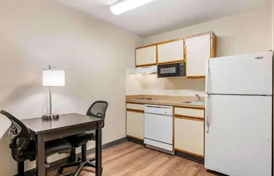 a small kitchen with a table and a refrigerator at Extended Stay America Suites - Cincinnati - Blue Ash - Reed Hartman in Blue Ash