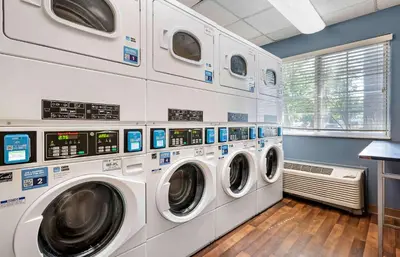 a bunch of washing machines in a laundry room at Extended Stay America Suites - Cincinnati - Blue Ash - Reed Hartman in Blue Ash