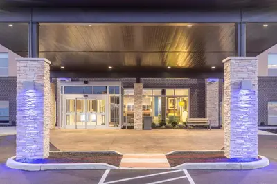a building with two brick pillars in a parking lot at Holiday Inn Express & Suites - Florence - Cincinnati Airport by IHG in Florence