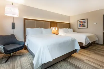 a hotel room with two beds and a chair at Holiday Inn Express & Suites - Florence - Cincinnati Airport by IHG in Florence