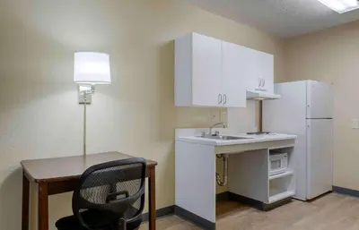 a small kitchen with a desk and a white refrigerator at Extended Stay America Suites - Cleveland - Airport - North Olmsted in North Olmsted