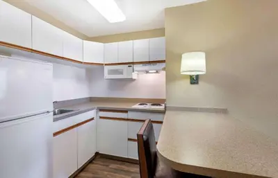 a kitchen with white cabinets and a table with a lamp at Extended Stay America Suites - Cleveland - Airport - North Olmsted in North Olmsted