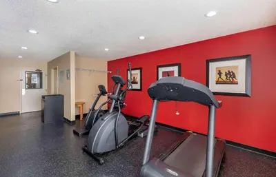 a gym with two exercise bikes and a red wall at Extended Stay America Suites - Cleveland - Airport - North Olmsted in North Olmsted