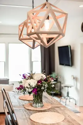 a wooden table with a vase of flowers and a light fixture at Studio 555 in Granville