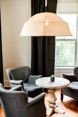 a living room with chairs and a table and a lamp at Studio 555 in Granville