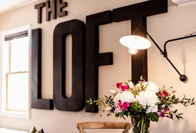 a table with a vase of flowers and a sign at The Loft in Granville