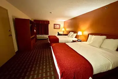 a hotel room with two beds with red sheets at Baymont by Wyndham Mason in Mason