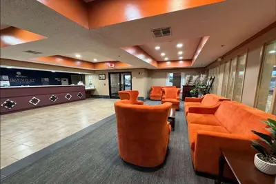 a lobby with orange chairs and a waiting room at Baymont by Wyndham Mason in Mason