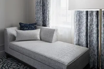 a couch sitting in a room with a window at The Lytle Park Hotel, Autograph Collection in Cincinnati