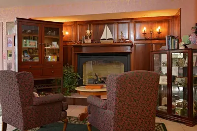 a living room with two chairs and a fireplace at OurGuest Inn & Suites Downtown Port Clinton in Port Clinton