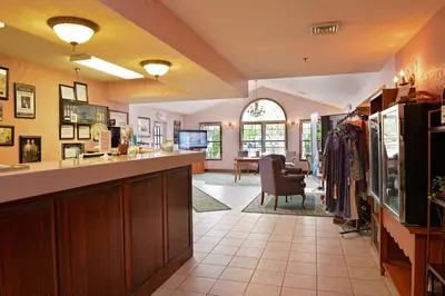 a kitchen with a counter and a living room at OurGuest Inn & Suites Downtown Port Clinton in Port Clinton
