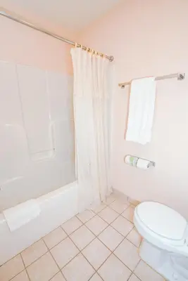 a bathroom with a toilet and a tub and a shower at OurGuest Inn & Suites Downtown Port Clinton in Port Clinton