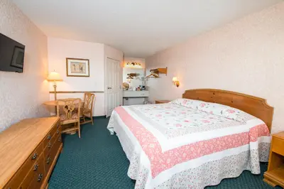 a hotel room with a bed and a table at OurGuest Inn & Suites Downtown Port Clinton in Port Clinton