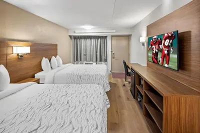 a hotel room with two beds and a flat screen tv at Red Roof Inn PLUS+ Columbus-Ohio State University OSU in Columbus