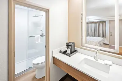 a bathroom with a sink and a toilet and a mirror at Red Roof Inn PLUS+ Columbus-Ohio State University OSU in Columbus