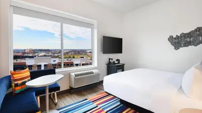 a hotel room with a bed and a large window at Aloft Cincinnati West Chester in West Chester