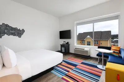 a bedroom with a white bed and a window at Aloft Cincinnati West Chester in West Chester