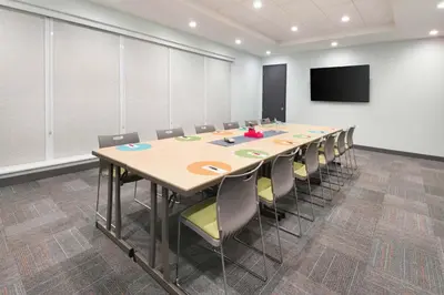 a conference room with a long table and chairs at Aloft Cincinnati West Chester in West Chester