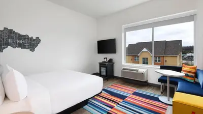 a bedroom with a white bed and a window at Aloft Cincinnati West Chester in West Chester