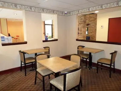 a dining room with two tables and chairs at Travelodge by Wyndham Cleveland Lakewood in Lakewood