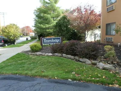 a sign in a yard in front of a building at Travelodge by Wyndham Cleveland Lakewood in Lakewood