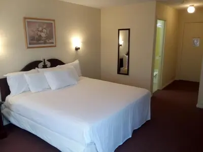 a bedroom with a large bed with white sheets at Walton Inn in Willard