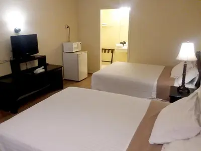 a hotel room with two beds and a television at Walton Inn in Willard