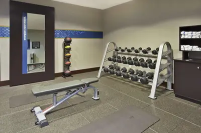 a gym with a bench and weights at Hampton Inn & Suites - Elyria in Elyria