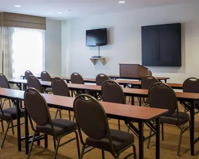 a classroom with tables and chairs and a blackboard at Sleep Inn & Suites Moundsville - Wheeling in Moundsville