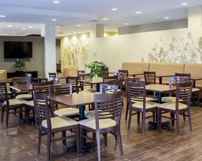 a dining room with tables and chairs in a restaurant at Sleep Inn & Suites Moundsville - Wheeling in Moundsville
