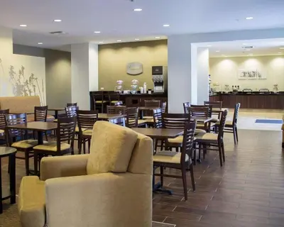 a restaurant with tables and chairs and a bar at Sleep Inn & Suites Moundsville - Wheeling in Moundsville