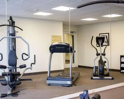 a gym with three exercise bikes in a room at Sleep Inn & Suites Moundsville - Wheeling in Moundsville