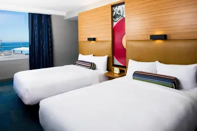 two beds in a hotel room with a window at Aloft Cleveland Downtown in Cleveland