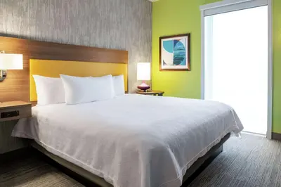 a large bed in a hotel room with a white bedspread at Home2 Suites By Hilton Dayton/Beavercreek, Oh in Beavercreek
