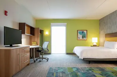 a hotel room with a bed and a flat screen tv at Home2 Suites By Hilton Dayton/Beavercreek, Oh in Beavercreek