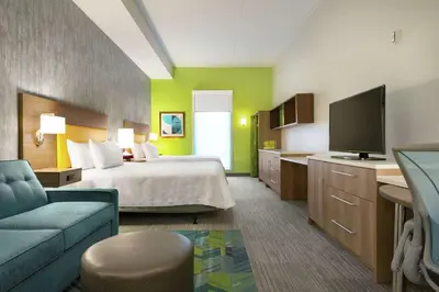 a hotel room with a bed and a flat screen tv at Home2 Suites By Hilton Dayton/Beavercreek, Oh in Beavercreek