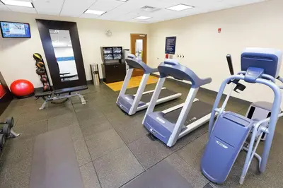 a gym with three treadmills and cardio equipment at Hampton Inn Waynesburg in Waynesburg