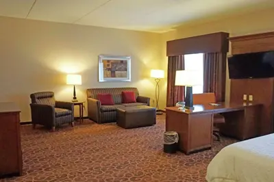 a hotel room with a bed and a desk and chair at Hampton Inn Waynesburg in Waynesburg