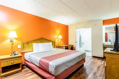a hotel room with a bed with an orange wall at Motel 6-Grove City, OH in Grove City
