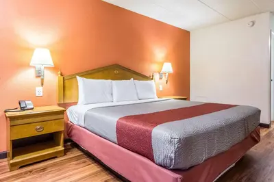 a large bed in a room with orange walls at Motel 6-Grove City, OH in Grove City