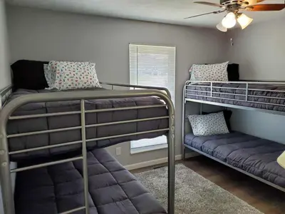 two bunk beds in a room with a ceiling fan at Liberty House in Bethany