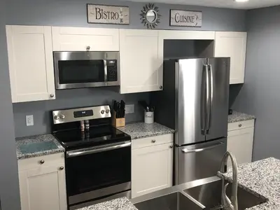 a kitchen with white cabinets and a stainless steel refrigerator at Liberty House in Bethany