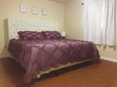 a bedroom with a purple bed and a window at Landon's Attached Home in Monroe