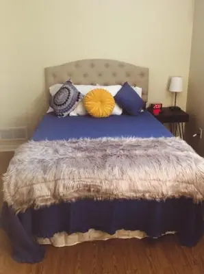 a bedroom with a blue bed with pillows on it at Landon's Attached Home in Monroe