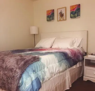 a bedroom with a bed with a colorful blanket on it at Landon's Attached Home in Monroe
