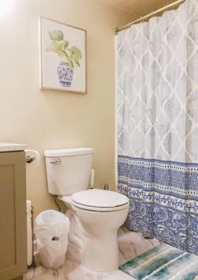 a bathroom with a toilet and a shower curtain at Landon's Attached Home in Monroe