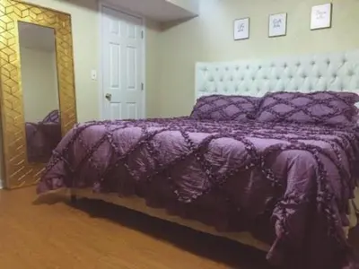a bedroom with a purple bed and a mirror at Landon's Attached Home in Monroe