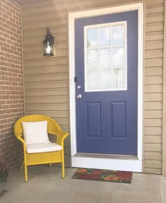 a blue door with a yellow chair and a white pillow at Landon's Attached Home in Monroe